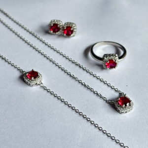 Elegant silver jewellery set with ruby red stones including pendant necklace, ring and stud earrings for women